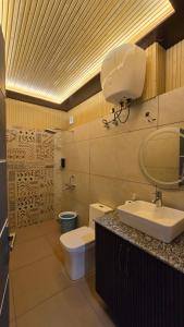 a bathroom with a sink and a toilet and a sink at Rosewood Cottage in Mukteshwar