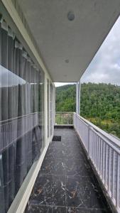 a balcony with a view of the woods at Rosewood Cottage in Mukteshwar