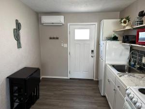 a kitchen with a sink and a white refrigerator at 1 Bedroom Wbalcony Near Unm, Nob Hill Downtown in Albuquerque +3 photos