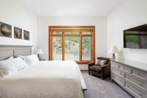 a white bedroom with a bed and a window at Elevated Alpine Escape Premium Snowmass Luxury in Snowmass Village
