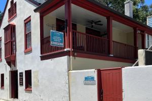a building with a red balcony and a sign on it at 20 Hypolita Street in St. Augustine