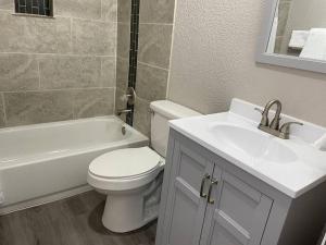 a bathroom with a toilet and a sink and a bath tub at 1 Bedroom Wbalcony Near Unm, Nob Hill Downtown in Albuquerque