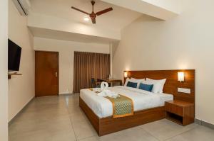 a bedroom with a large bed with a ceiling fan at Sri Ramakrishna Hotel in Bangalore