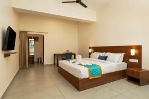 a hotel room with a bed and a television at Sri Ramakrishna Hotel in Bangalore