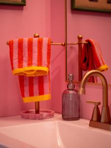 a bathroom sink with red and yellow towels on a holder at Arts District Walk to Restaurants, Bars Sleeps 8 -Tillman in Cleveland