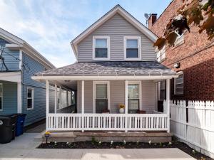 a house with a white porch and a white fence at Arts District Walk to Restaurants, Bars Sleeps 8 -Tillman in Cleveland