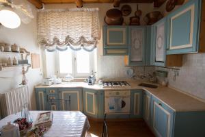 cocina con armarios azules, mesa y ventana en Antica Maison, en Ascoli Piceno