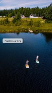 two people riding on paddle boards in the water at Smith Lake Farm in Merville +44 photos