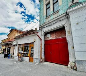 a building with red garage doors on a street at Ming with free parking in Braşov +10 photos