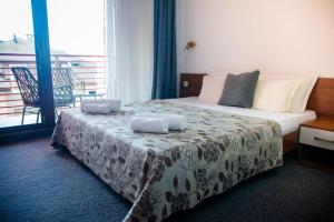 a hotel room with a bed and a balcony at Sea house Afrodita1-rooms in Nesebar