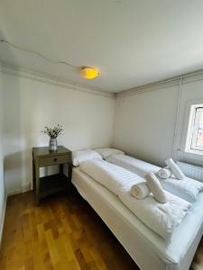 two beds in a room with a table and a window at Ilulissat Stay - Siku in Ilulissat