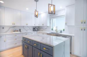 eine Küche mit weißen Schränken und einer großen weißen Insel in der Unterkunft Luxury ATL Home Near East Lake Golf & Beltline in Atlanta