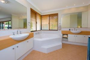 La salle de bains est pourvue de 2 lavabos, d'une baignoire et de miroirs. dans l'établissement Sky Blue Retreat Serene Family Getaway, à North Boyanup 28 autres photos