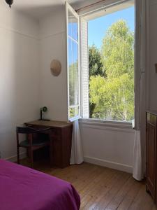 a bedroom with a window and a desk and a bed at Maison charmante - 10 min de Paris in Montreuil +30 photos