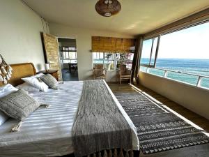 a bedroom with a large bed with a view of the ocean at Beach front villa , All Mare 2 in Uluwatu