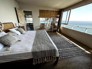 a bedroom with a bed with a view of the ocean at Beach front villa , All Mare 2 in Uluwatu