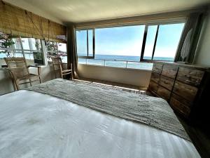 a bedroom with a large bed with a view of the ocean at Beach front villa , All Mare 2 in Uluwatu