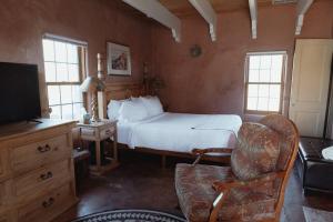 a bedroom with a bed and a couch and a tv at Stay Old Town Road in Albuquerque