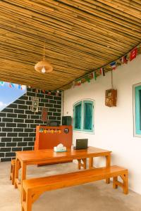 a table and two benches under a wooden ceiling at Casa De' Summer Banyuwangi in Banyuwangi