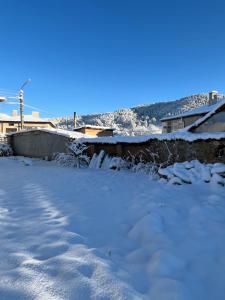 a yard covered in snow with a waterfall at Къща Христини in Kalofer