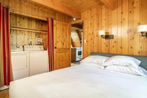 ein Schlafzimmer mit einem Bett in einem Zimmer mit Holzwänden in der Unterkunft Idyllcove Spa, Fenced-yard, Ac, Fireplace, Dog Ok in Idyllwild + 22 Fotos