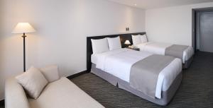 a hotel room with two beds and a couch at Hotel President in Seoul