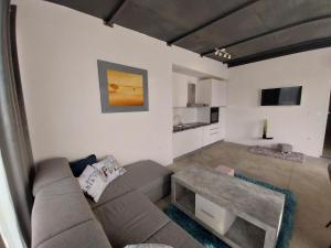 a living room with a couch and a table at Hacienda MATEA an oasis of romance near the beaches, surrounded by olive trees, pool, jacuzzi and playground, Pula - Istria in Pula