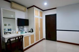 a room with a kitchen with a sink and a tv at Sampheng House in Bangkok