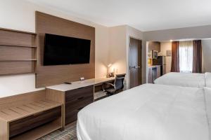 a hotel room with a bed and a desk and a tv at MainStay Suites Lebanon - Nashville Area in Lebanon