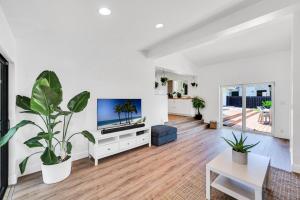 フォート・ローダーデールにあるCentrally Located Heated pool Lush Tropical Surrounding Oasis Key RESlDENCESの白いリビングルーム(テレビ、植物付)