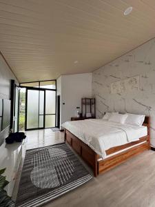 a bedroom with a large bed with a stone wall at Senara Resort Ciwidey in Baruhtunggul +24 photos