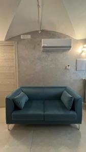 a blue couch in a living room with a air conditioner at Il Duomo in Bovino
