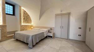 a white bedroom with a bed and a window at Il Duomo in Bovino