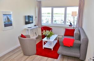 a living room with two chairs and a red rug at Am Rundsteg 9 in Burgtiefe auf Fehmarn 