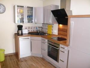 a small kitchen with white cabinets and a sink at Aloha 2 in Neue Tiefe Fehmarn