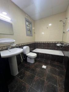 a bathroom with a sink and a tub and a toilet at MANAZEL ladies and Family stay only corniche in Khor Fakkan
