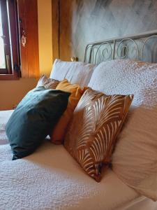 ナジュマロシュにあるFecskefészek vendégházの枕が4つ置かれたベッド