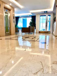 a lobby with a large marble floor with chairs and windows at Pera Arya Hotel in Istanbul