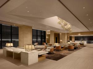 a lobby of a hotel with tables and chairs at Shillamonogram Gangneung Hotel in Gangneung