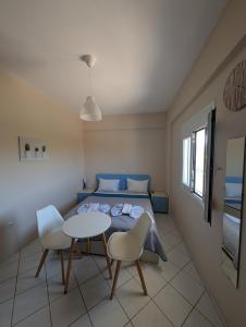 a bedroom with a bed and a table and chairs at Pame Apartments Only Adults in Valanidorachi +35 photos
