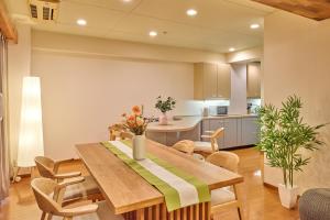 a kitchen and dining room with a wooden table and chairs at nel shizuoka in Shizuoka