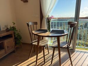 a table with two chairs and a vase with flowers on it at Avtalyon Wood accommodation in Avtalyon
