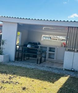 a patio area with a table and a refrigerator at Knovi Guesthouse in Bulawayo