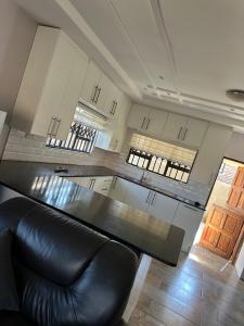 a kitchen with a black table and a black leather couch at Knovi Guesthouse in Bulawayo