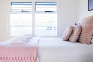 a bedroom with a bed with pink blankets and a window at The Elm Apartments - The Pink Room in Orange +14 photos