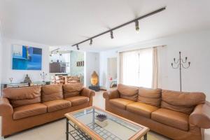 een woonkamer met twee banken en een tafel bij La Quinta Heights -6 Bed Villa-private Pool in San Miguel de Abona
