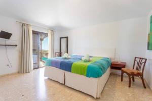 een slaapkamer met een bed met een kleurrijke deken bij La Quinta Heights -6 Bed Villa-private Pool in San Miguel de Abona +42 foto's