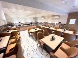 a dining room with tables and chairs at Hotel Comfort in Surat
