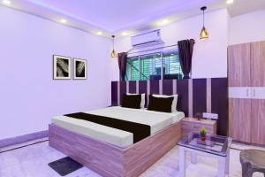 a bedroom with a bed and a table in it at Hotel O Stay Inn in Kolkata +43 photos