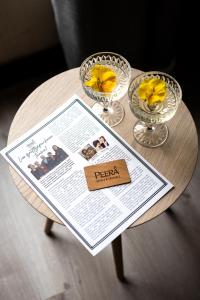 a table with two wine glasses and a newspaper on it at Hotelli Sodankylä in Sodankylä